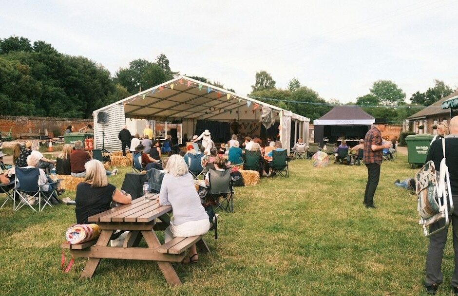 Publikum samles til utendørs festivalarrangement foran en scene